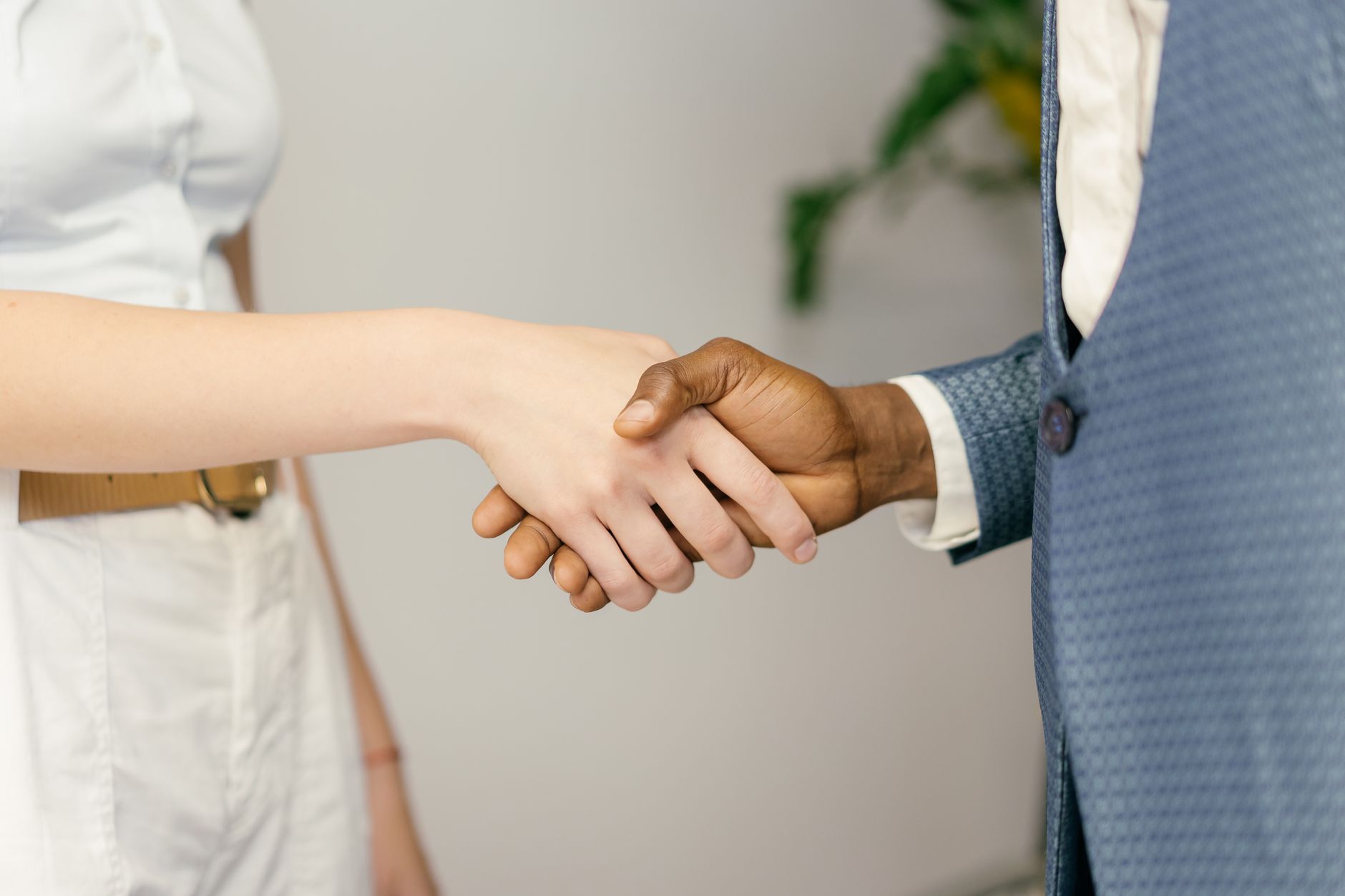 Aperto de mãos entre duas pessoas em fundo claro